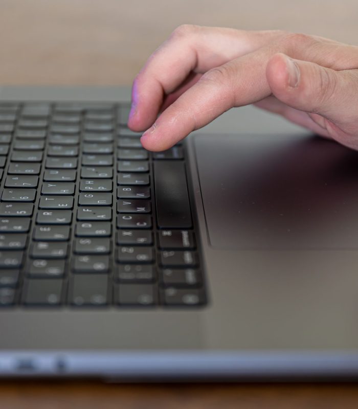 Close-up, male hands are typing on the keys of a laptop.